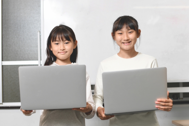 パソコンを持つ複数の女子学生達